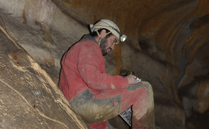 Geologist Iñaki Intxaurbe wearing head lamp in a cave