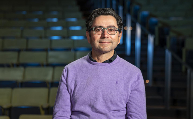 Nobel laureate Ardem Patapoutian standing in empty lecture hall