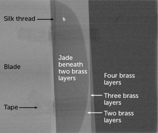 An image of the replica dagger-axe using neutron imaging. The image is in shades of gray with materials labeled.