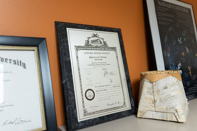 A photograph of a framed patent featuring the bolded phrase: "Krystal S. Tsosie" "- INVENTOR -"