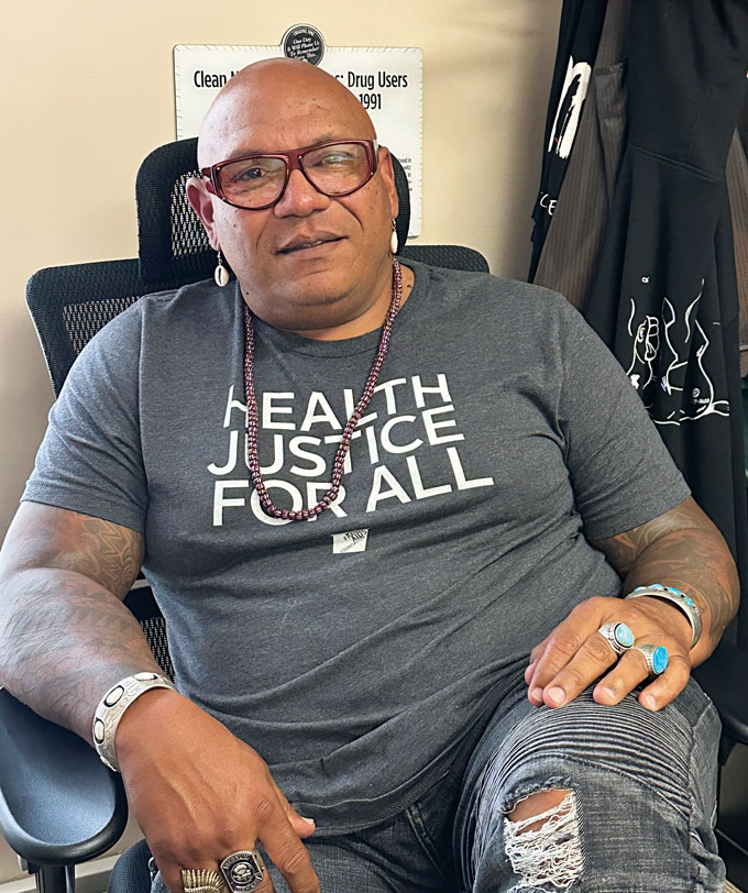 A man wearing a T-shirt that says "Health Justice For All"