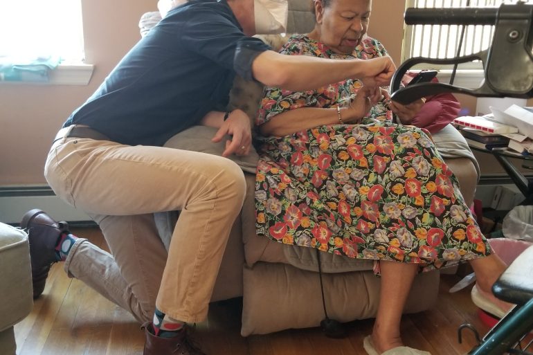 A doctor performs at home medical assessment of a senior female.